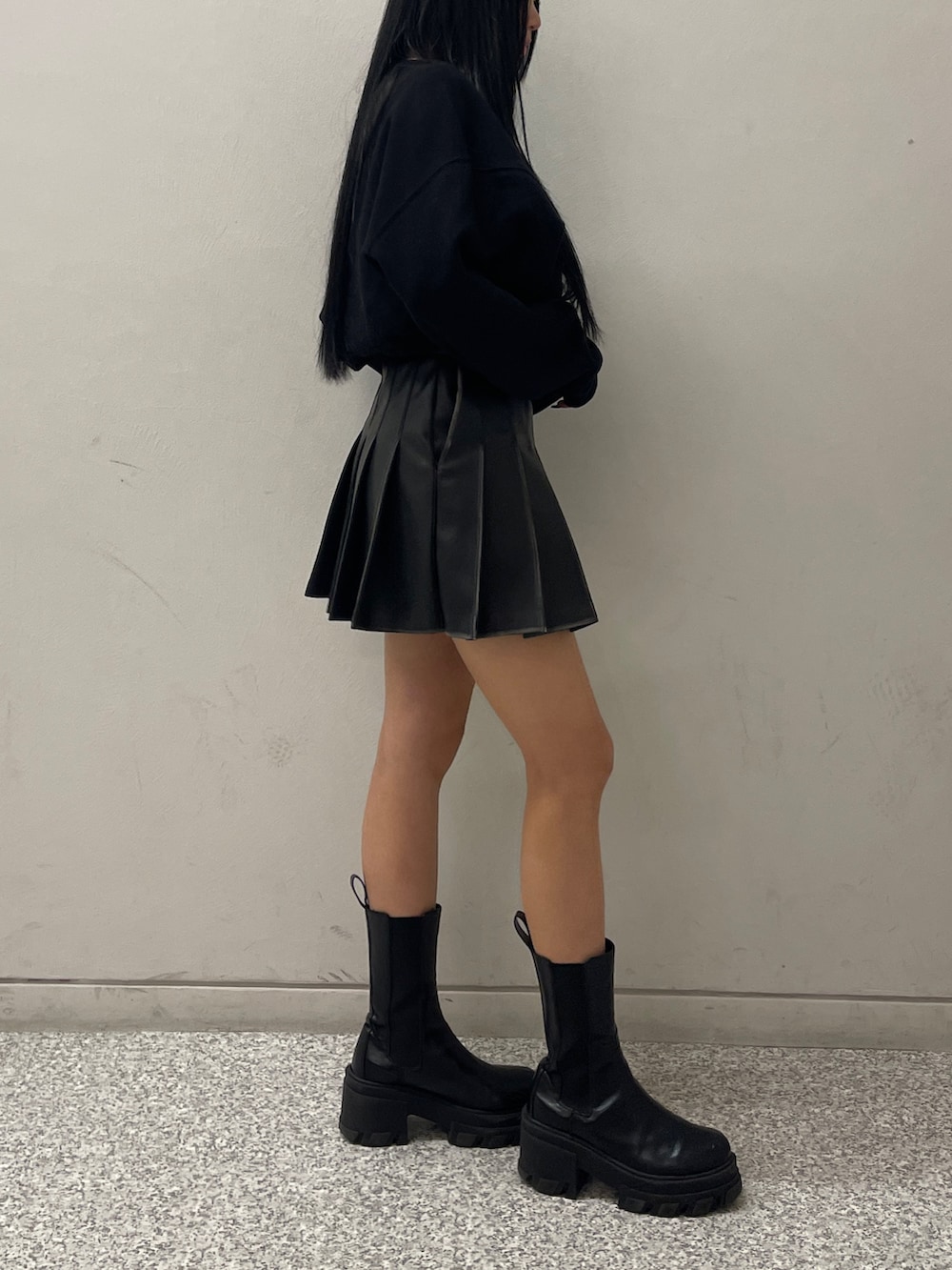 ブラック系のTシャツ/カットソー、ブラック系のスカート、ブラック系のブーツを着用したレディースの冬コーディネートの3枚目の写真