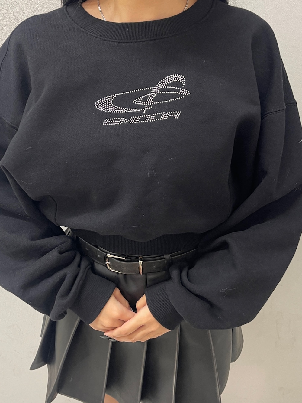 ブラック系のTシャツ/カットソー、ブラック系のスカート、ブラック系のブーツを着用したレディースの冬コーディネートの5枚目の写真