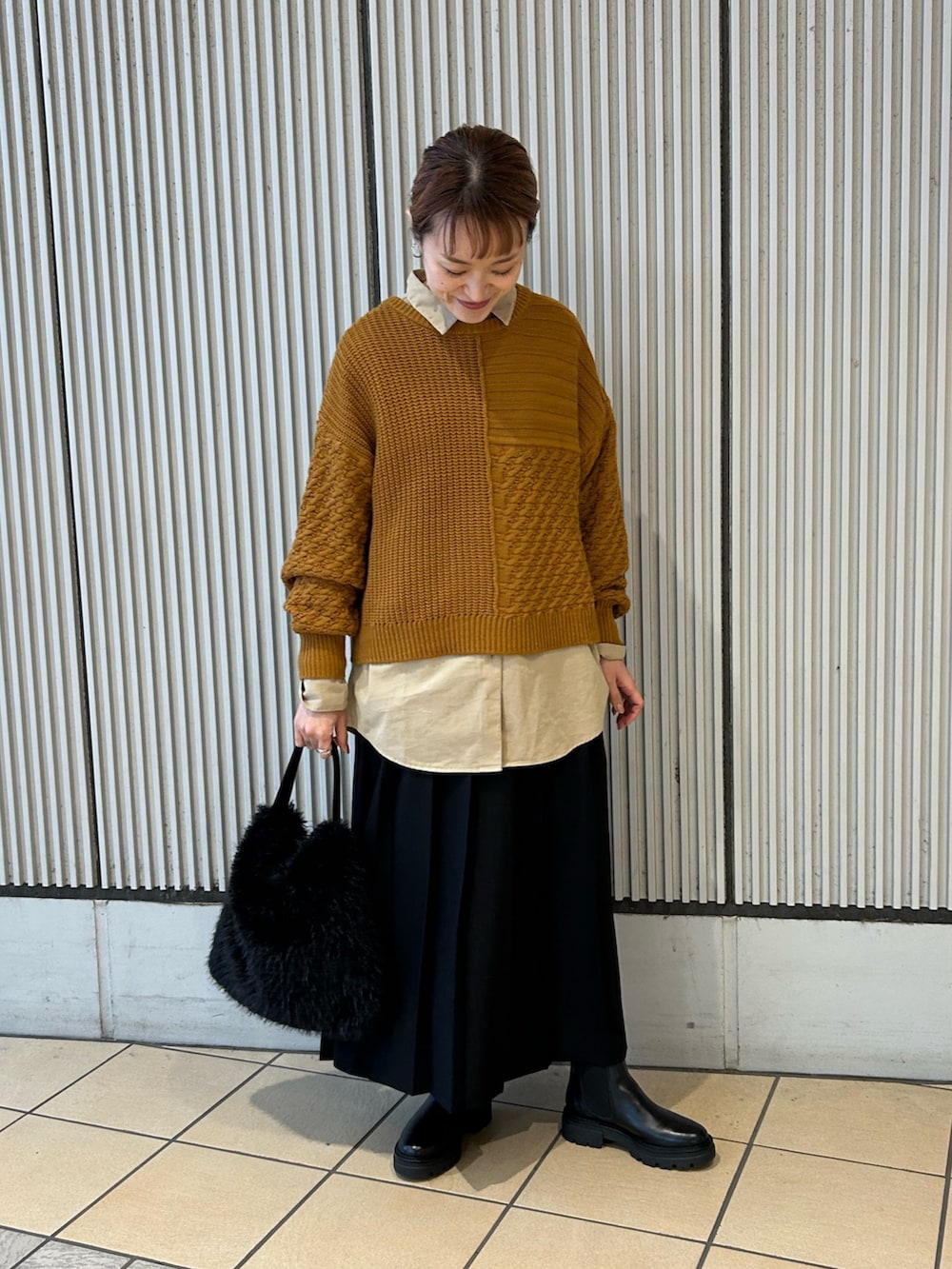 ゴールド系のニット/セーター、パープル系のシャツ/ブラウス、ブラック系のスカートを着用したレディースの冬コーディネートの3枚目の写真