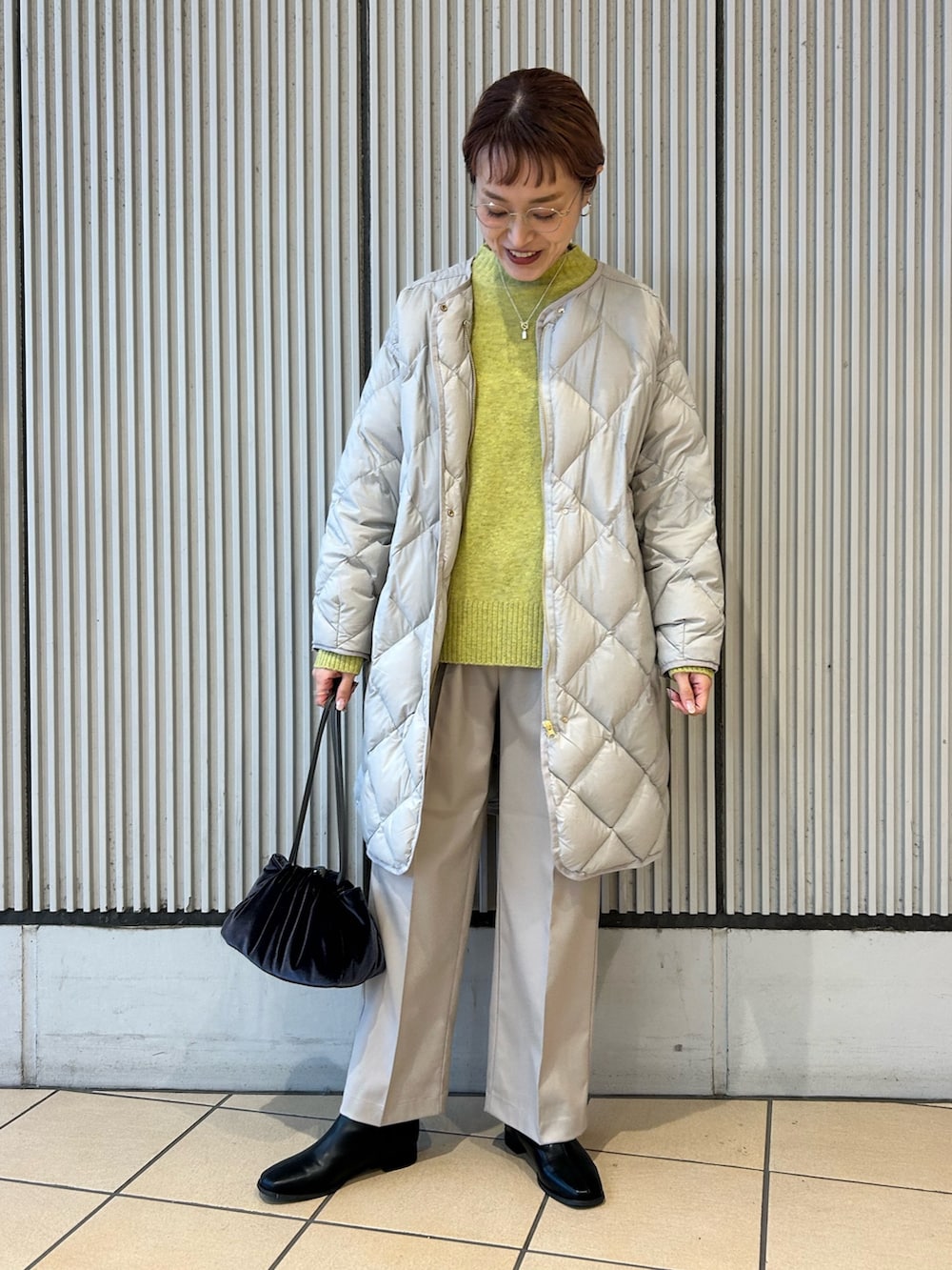 グリーン系のニット/セーター、ベージュ系のその他パンツ、ブラック系のブーツを着用したレディースの冬コーディネートの3枚目の写真