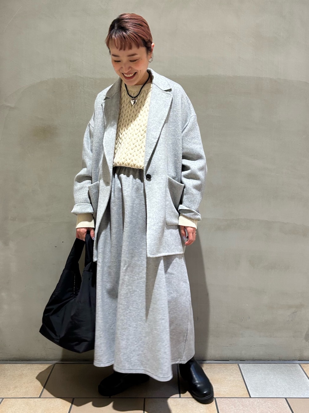 グレー系のその他アウター、ベージュ系のニット/セーター、グレー系のスカートを着用したレディースの冬コーディネートの4枚目の写真