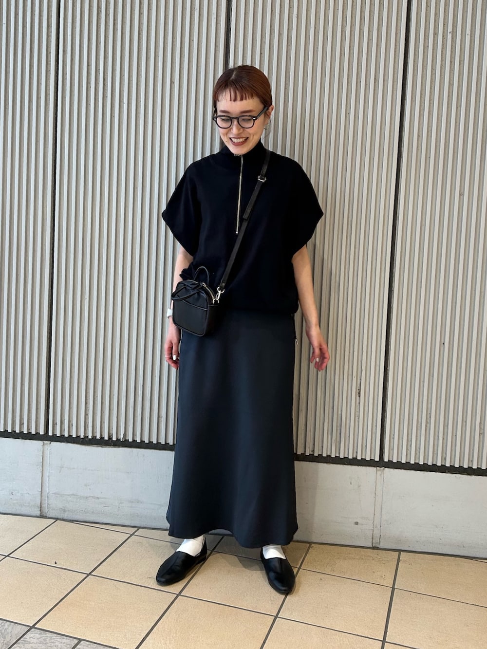 ブラック系のその他トップス、ブルー系のスカート、ブラック系のショルダーバッグを着用したレディースの春コーディネートの3枚目の写真