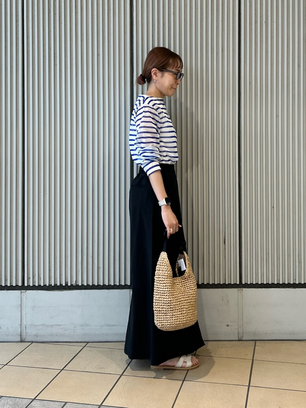 ブルー系のTシャツ/カットソー、ブラック系のスカート、ホワイト系のサンダルを着用したレディースの夏コーディネートの2枚目の写真