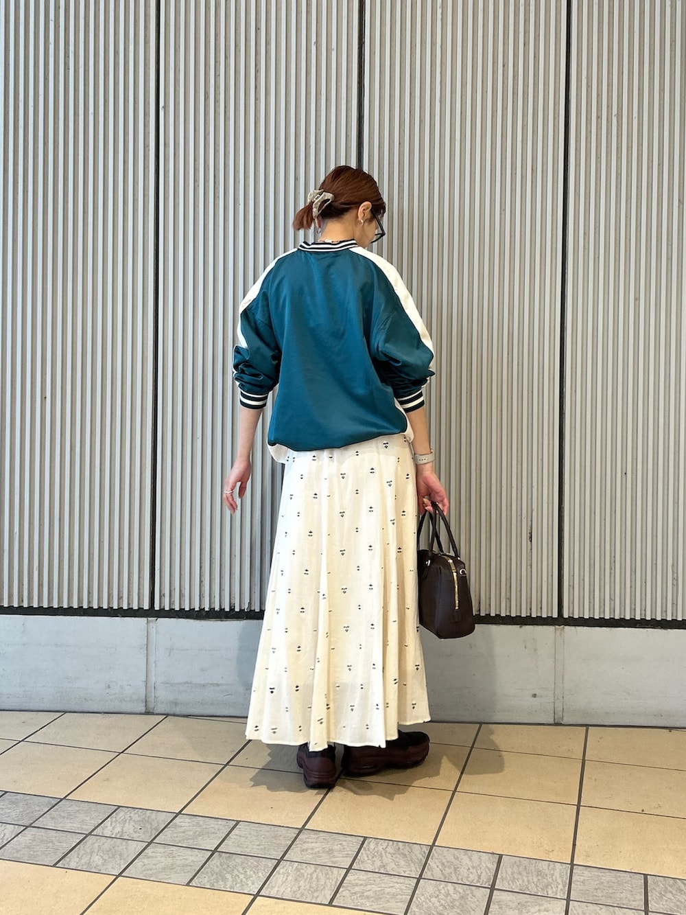 ホワイト系のスカート、グリーン系のその他トップス、レッド系のスニーカーを着用したレディースの春コーディネートの3枚目の写真