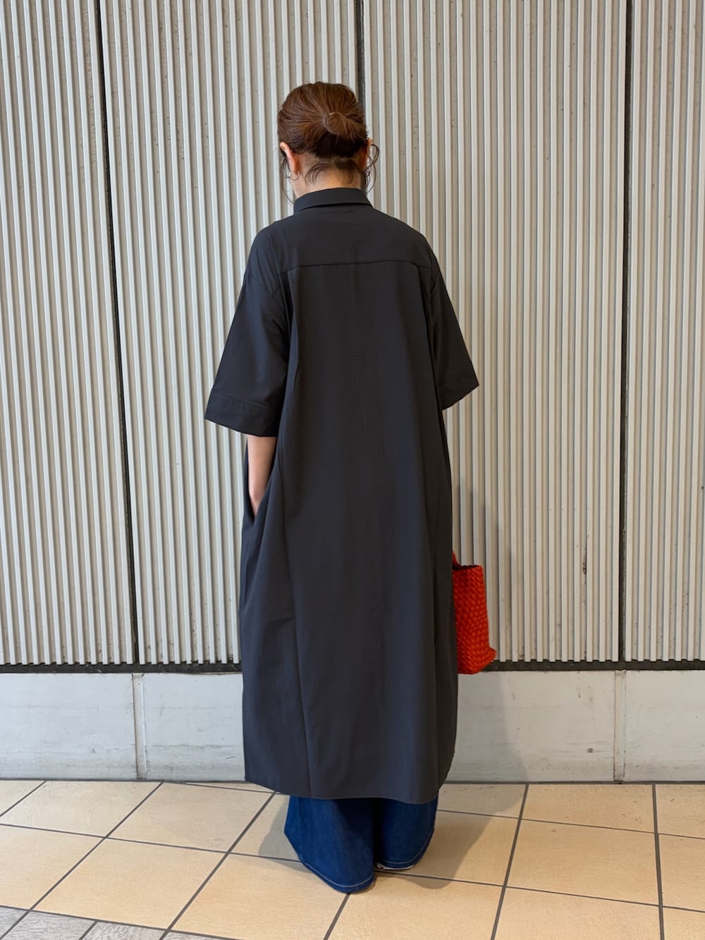ブルー系のワンピース、ピンク系のスニーカー、レッド系のハンドバッグを着用したレディースの夏コーディネートの2枚目の写真