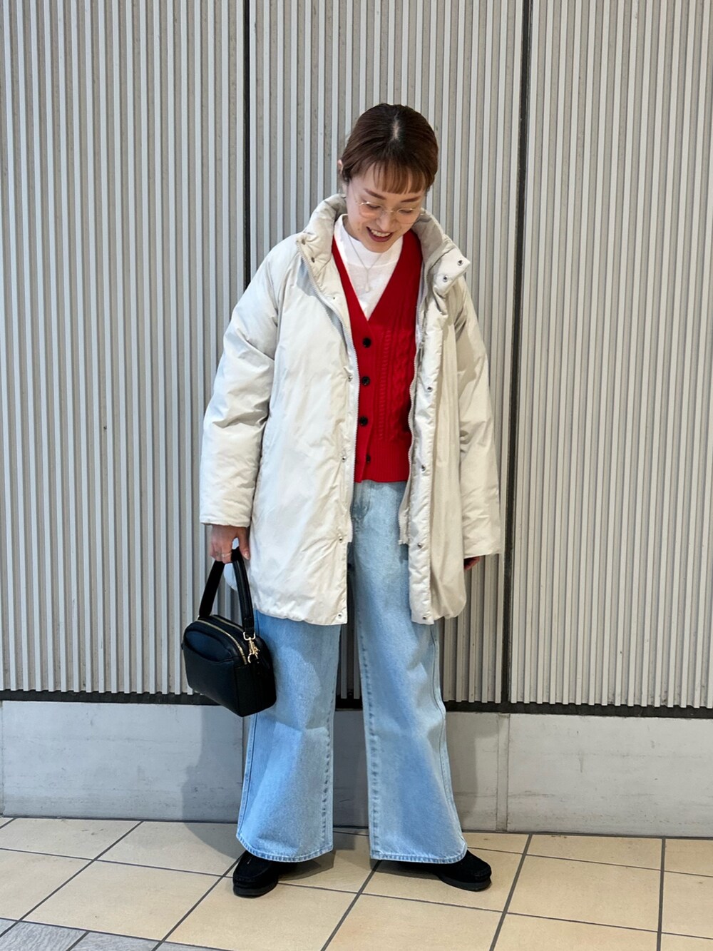 レッド系のカーディガン/ボレロ、ブルー系のデニムパンツ、ブラック系のショルダーバッグを着用したレディースの冬コーディネートの5枚目の写真