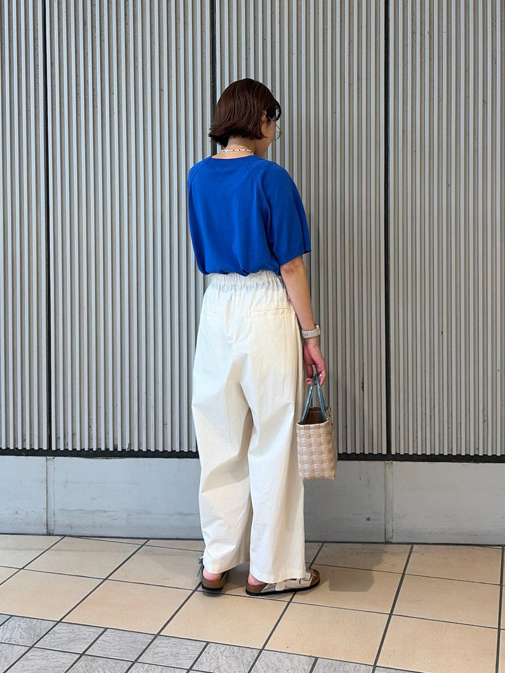 ブルー系のニット/セーター、ホワイト系のその他パンツ、シルバー系のサンダルを着用したレディースの夏コーディネートの2枚目の写真