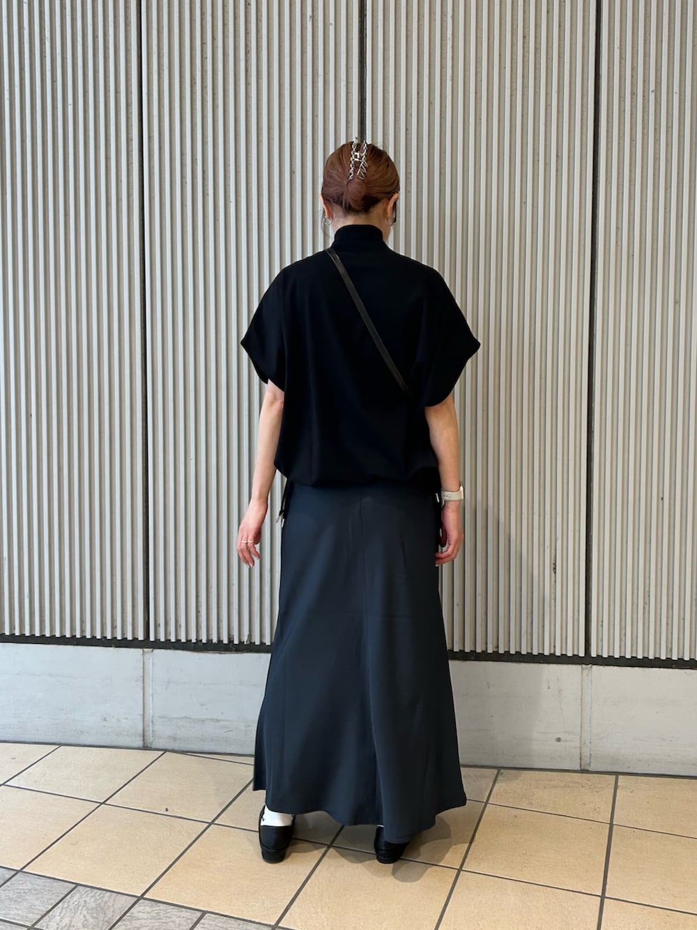 ブラック系のその他トップス、ブルー系のスカート、ブラック系のショルダーバッグを着用したレディースの春コーディネートの2枚目の写真