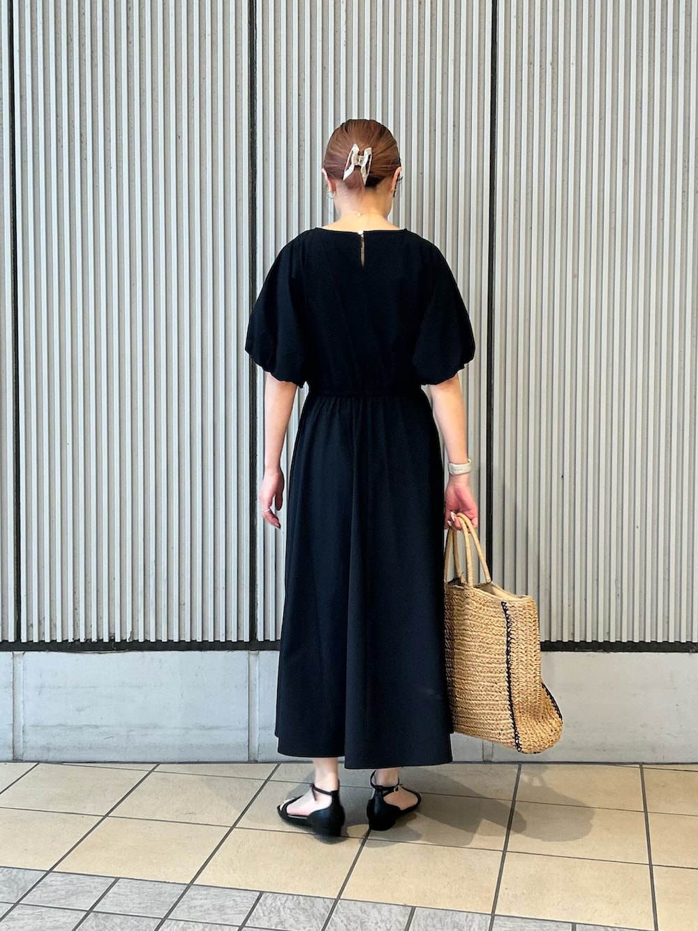 ベージュ系のトートバッグ、ブラック系のサンダル、ブラック系のワンピースを着用したレディースの春コーディネートの3枚目の写真
