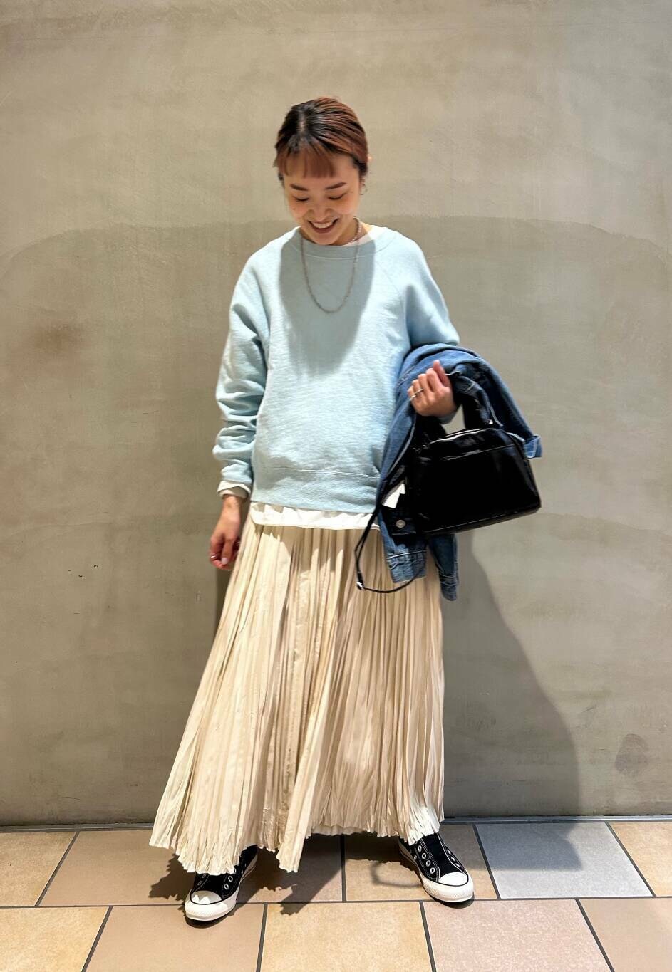ブラック系のショルダーバッグ、ホワイト系のTシャツ/カットソー、ブルー系のスウェットを着用したレディースの冬コーディネートの3枚目の写真