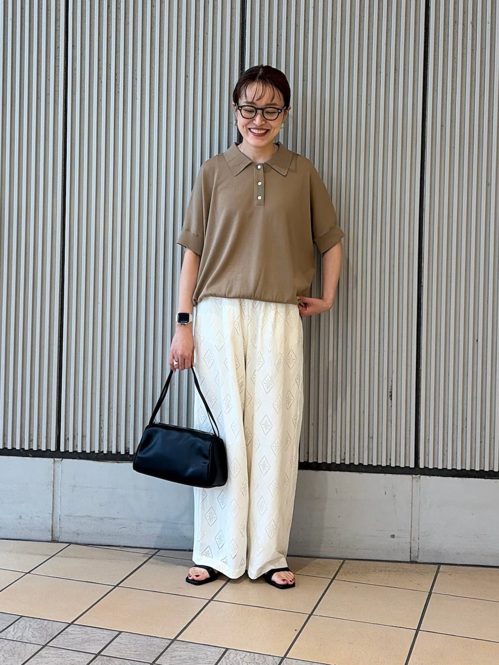 ベージュ系のニット/セーター、ホワイト系のその他パンツ、ブラック系のサンダルを着用したレディースの夏コーディネートの3枚目の写真