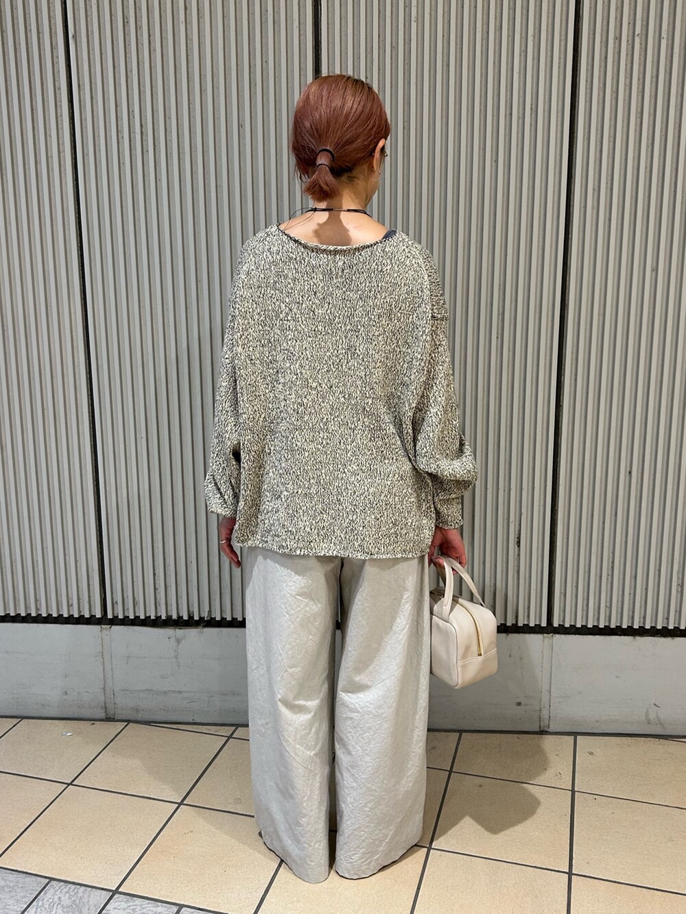 ベージュ系のニット/セーター、グレー系のその他パンツ、ホワイト系のブーツを着用したレディースの秋コーディネートの2枚目の写真