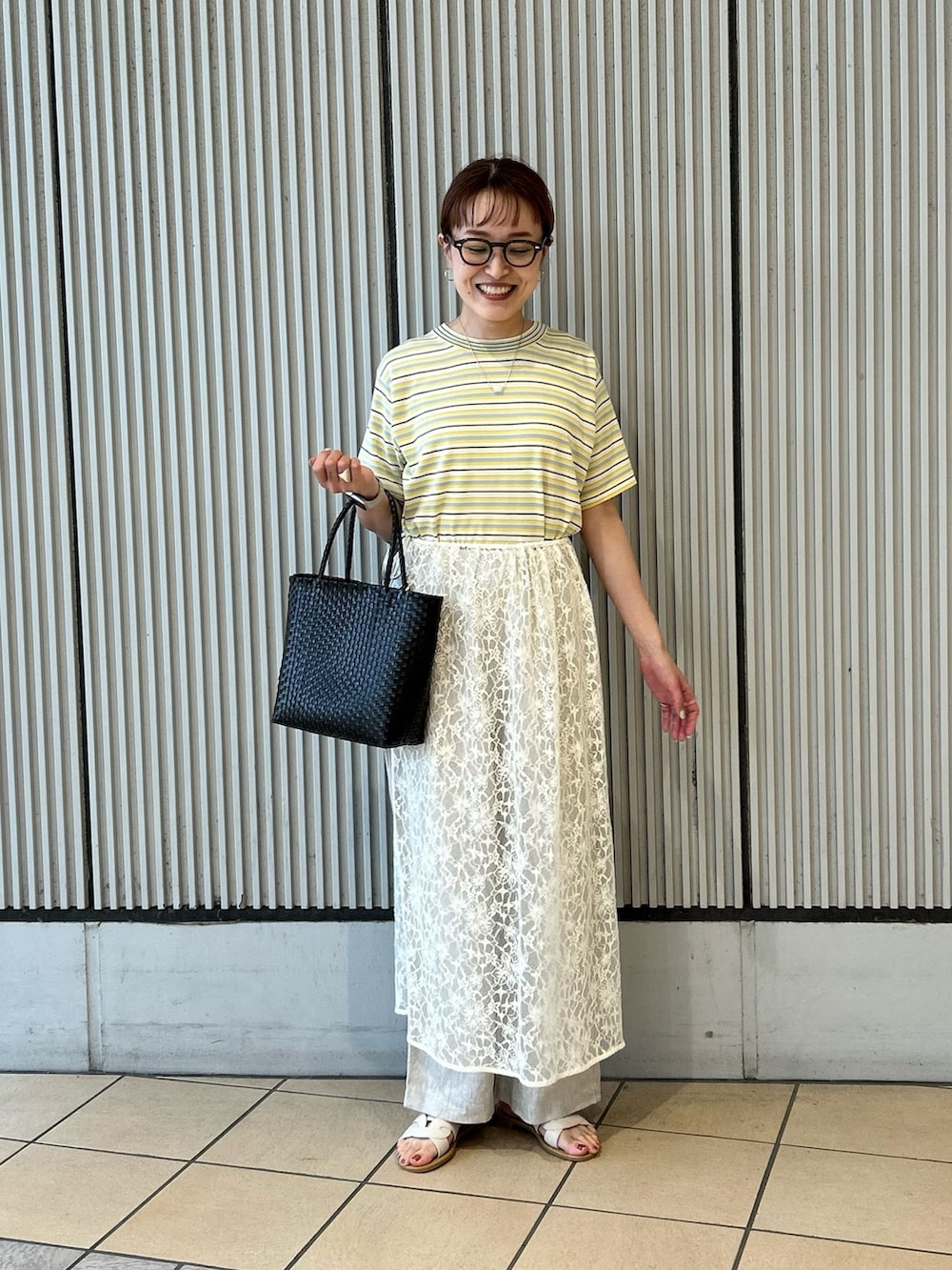 ブラウン系のかごバッグ、ベージュ系のその他パンツ、ホワイト系のサンダルを着用したレディースの夏コーディネートの4枚目の写真