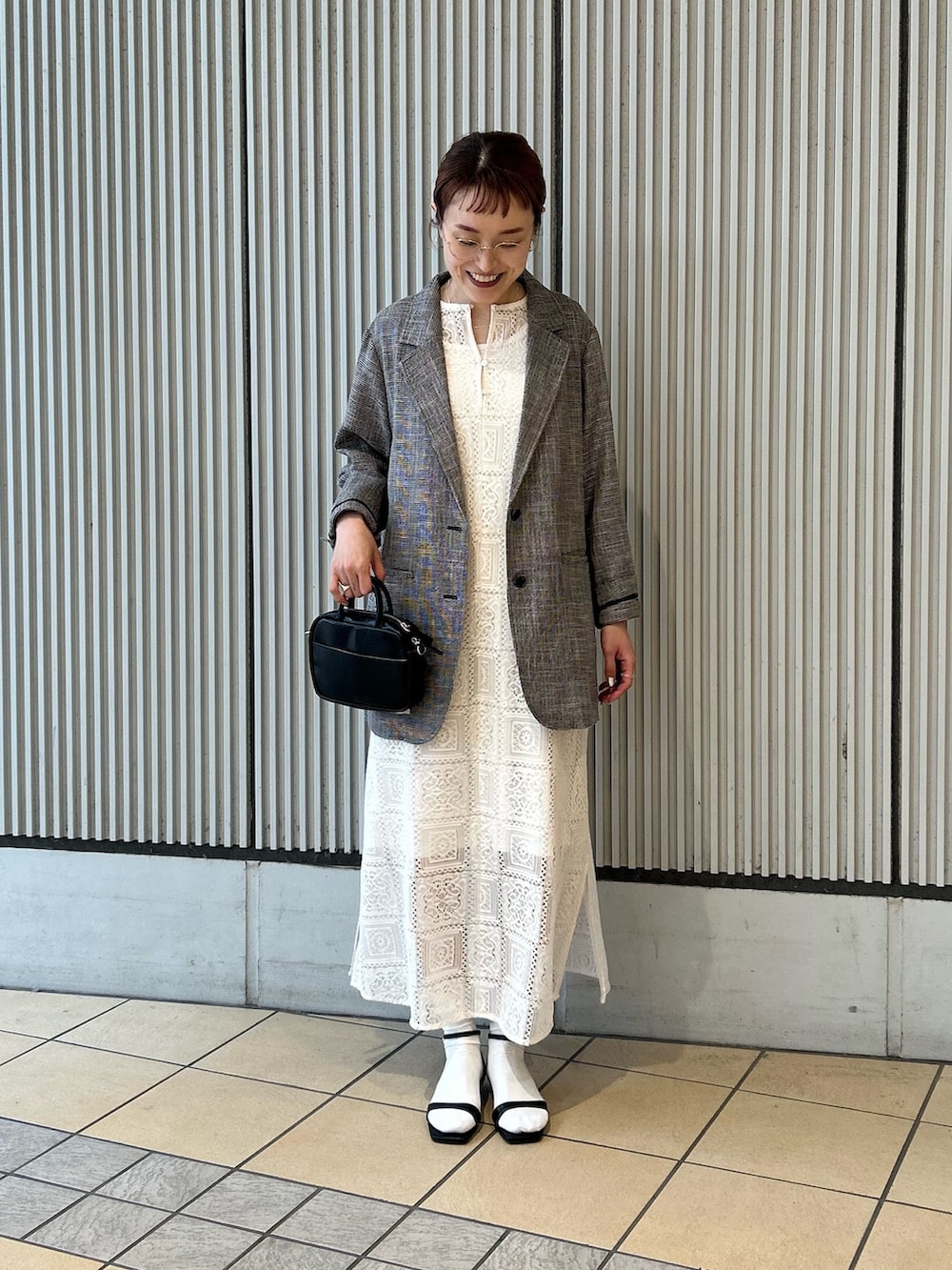 ベージュ系のワンピース、ブラック系のサンダル、ブラック系のショルダーバッグを着用したレディースの春コーディネートの7枚目の写真