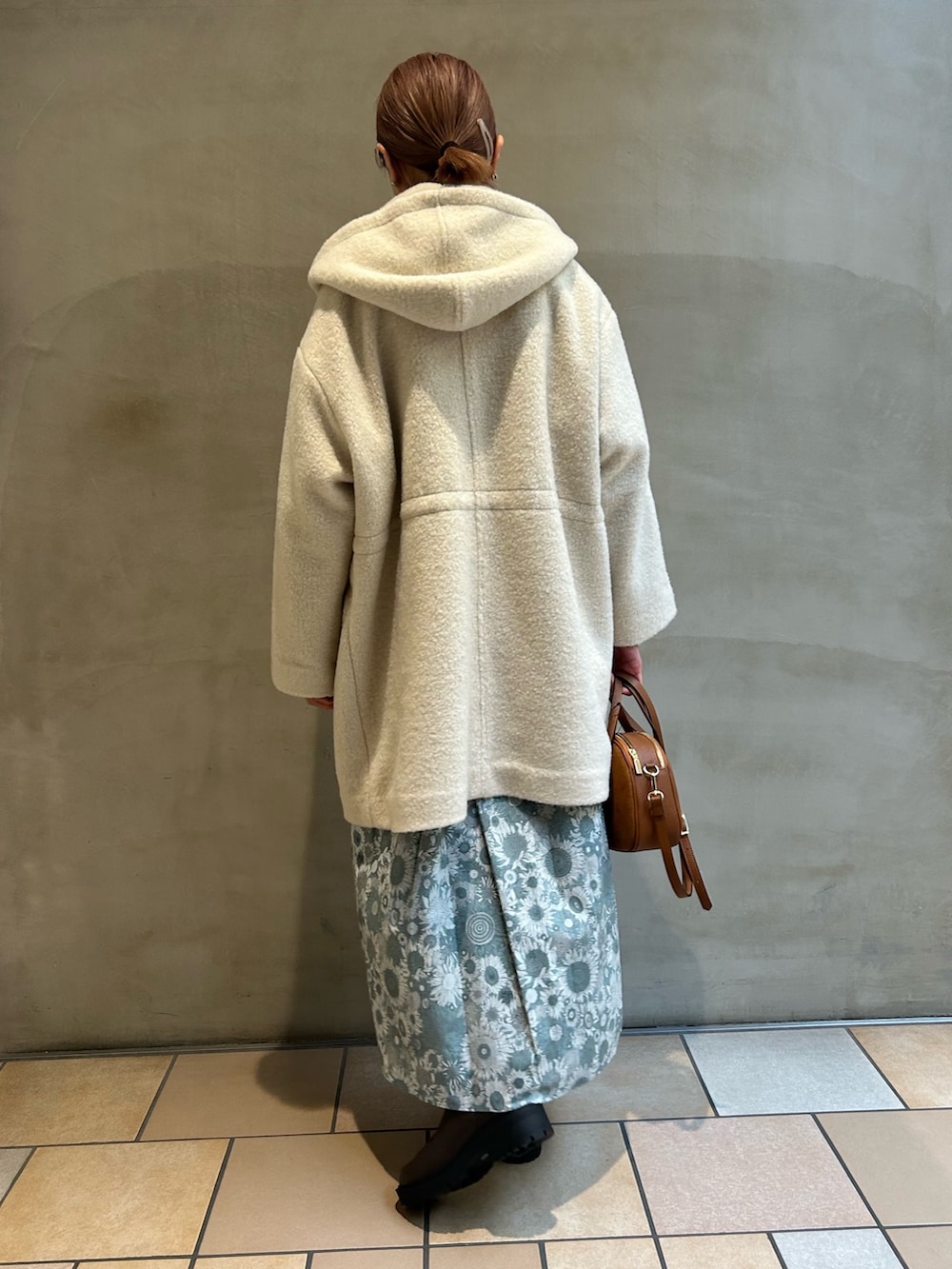 ホワイト系のTシャツ/カットソー、ブルー系のニット/セーター、ブラック系のスカートを着用したレディースの冬コーディネートの2枚目の写真