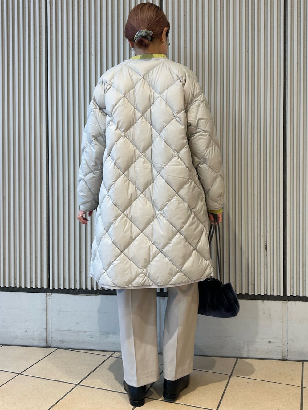 グリーン系のニット/セーター、ベージュ系のその他パンツ、ブラック系のブーツを着用したレディースの冬コーディネートの4枚目の写真