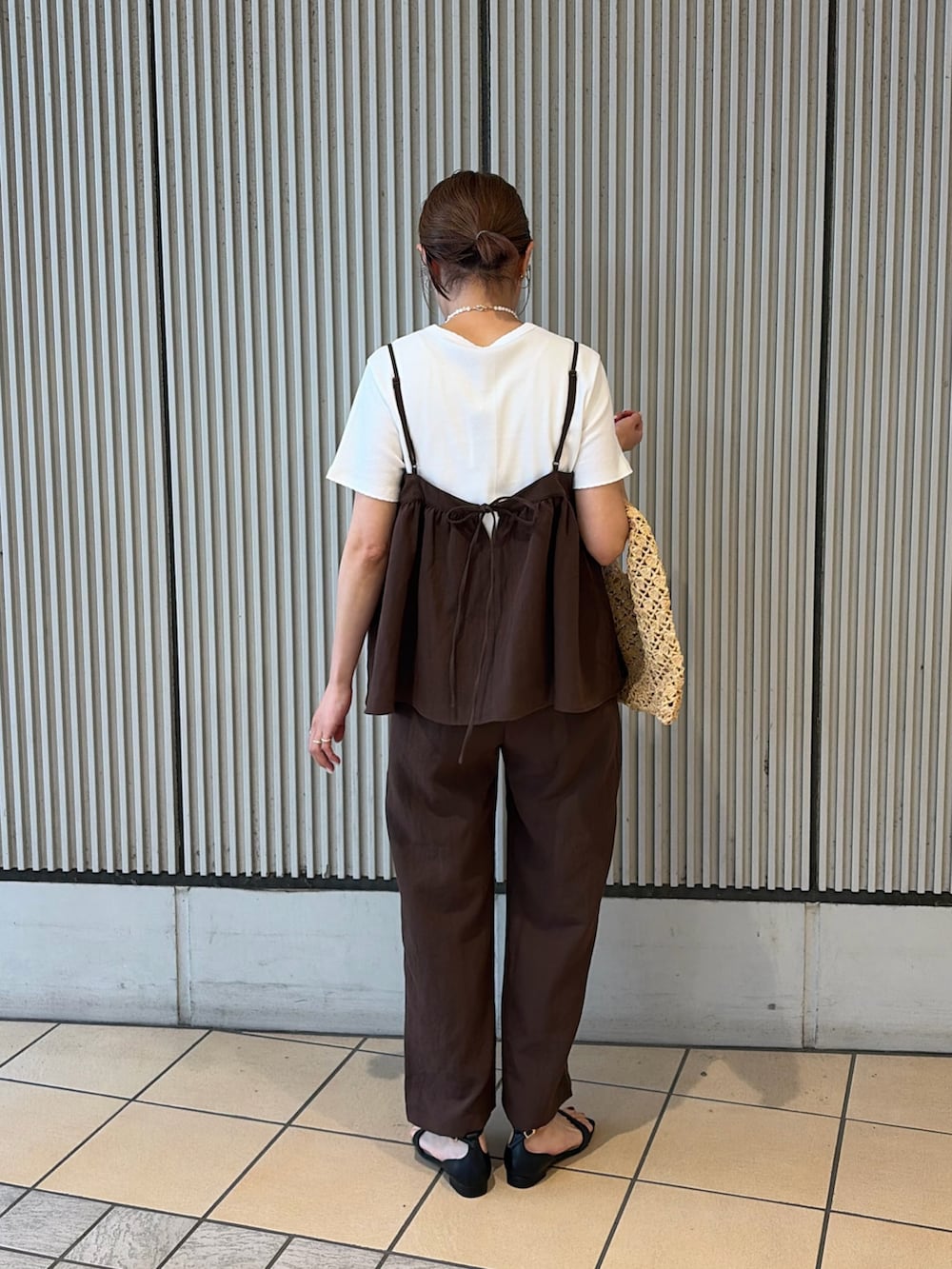 ホワイト系のTシャツ/カットソー、ブラック系のサンダル、ベージュ系のハンドバッグを着用したレディースの夏コーディネートの2枚目の写真