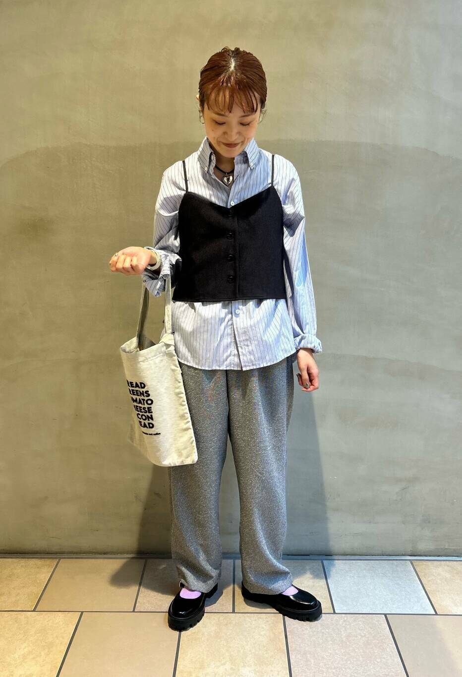 グレー系のその他パンツ、グレー系のトートバッグ、ブルー系のシャツ/ブラウスを着用したレディースの秋コーディネートの2枚目の写真