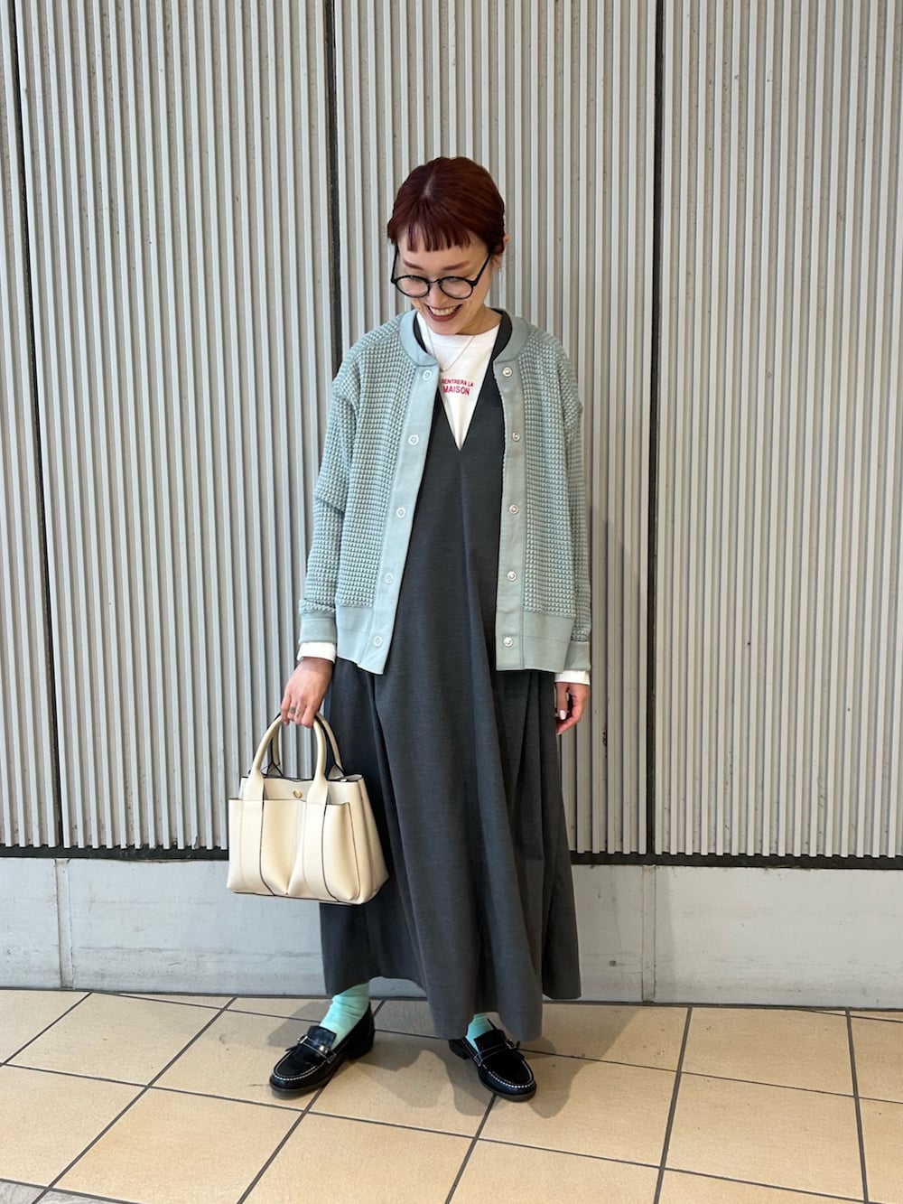 グリーン系のカーディガン/ボレロ、グレー系のワンピース、ブラック系のローファーを着用したレディースの冬コーディネートの3枚目の写真