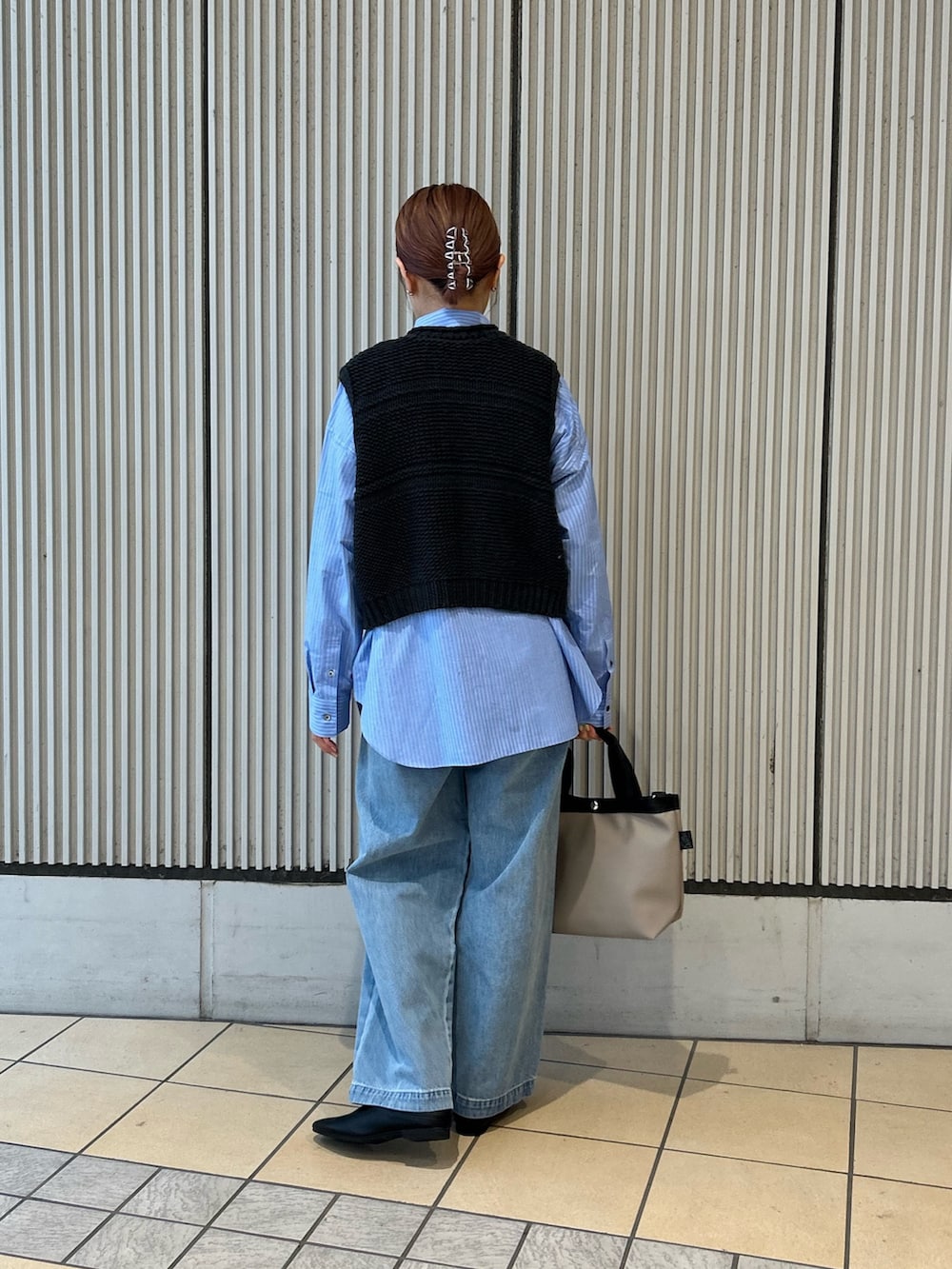 ブラック系のベスト、ブルー系のシャツ/ブラウス、ブルー系のデニムパンツを着用したレディースの冬コーディネートの3枚目の写真