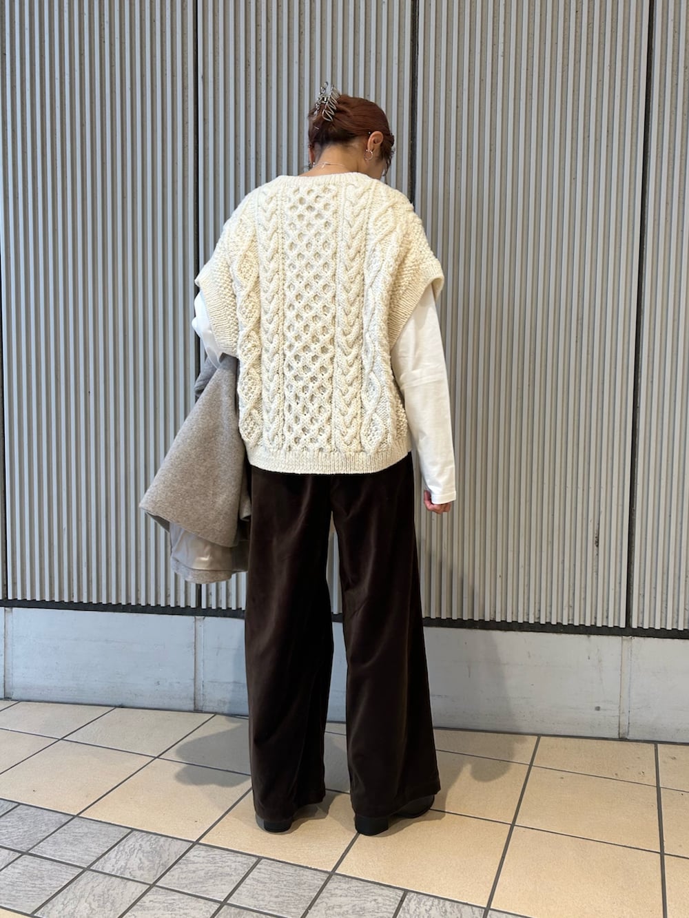 ホワイト系のニット/セーター、ブラウン系のその他パンツ、ブラック系のブーツを着用したレディースの秋コーディネートの5枚目の写真