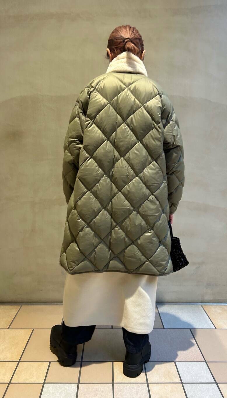 ブラック系のショルダーバッグ、グリーン系のダウンジャケット/コート、ブラック系のブーツを着用したレディースの冬コーディネートの2枚目の写真