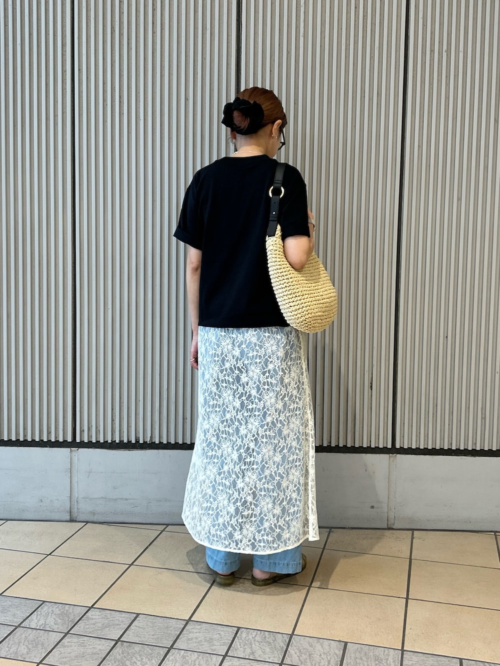 ブラック系のTシャツ/カットソー、ホワイト系のワンピース、ブルー系のデニムパンツを着用したレディースの春コーディネートの3枚目の写真