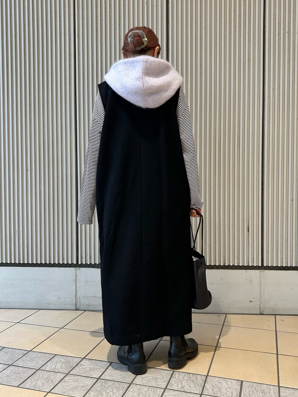 ブラック系のワンピース、ブラック系のTシャツ/カットソー、ブラック系のショルダーバッグを着用したレディースの秋コーディネートの3枚目の写真