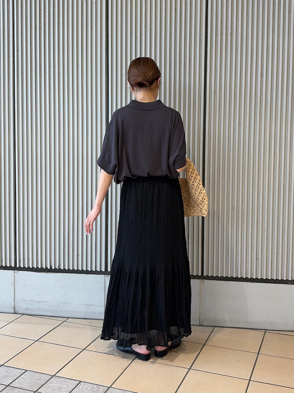 グレー系のニット/セーター、ブラック系のスカート、ブラック系のその他シューズを着用したレディースの夏コーディネートの2枚目の写真