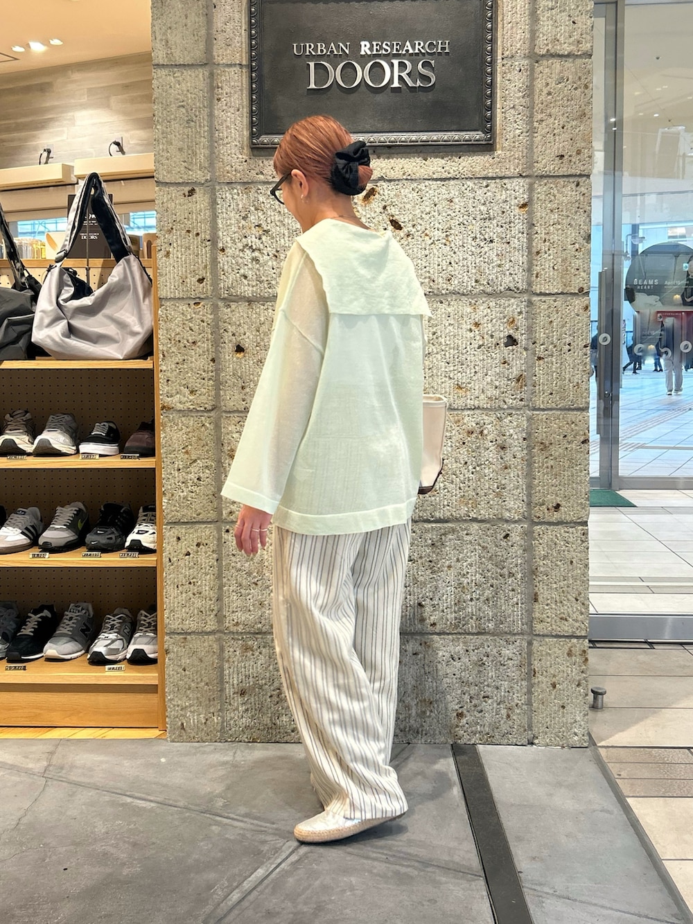 ベージュ系のその他パンツ、シルバー系のスリッポン、グリーン系のトートバッグを着用したレディースの春コーディネートの3枚目の写真