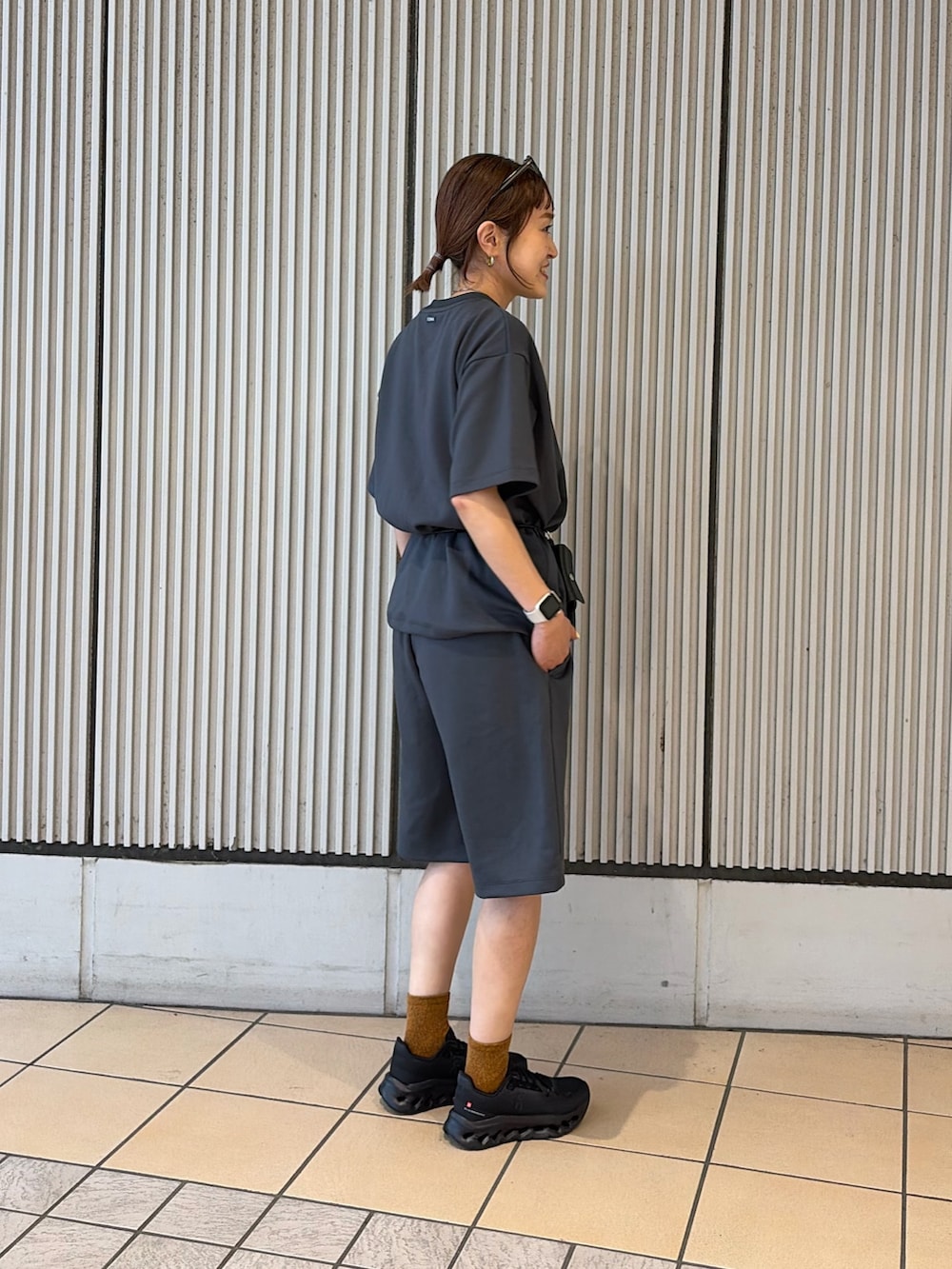 ブラック系のスニーカー、グレー系のルームウェア/パジャマ、ブラック系のポーチを着用したレディースの夏コーディネートの2枚目の写真