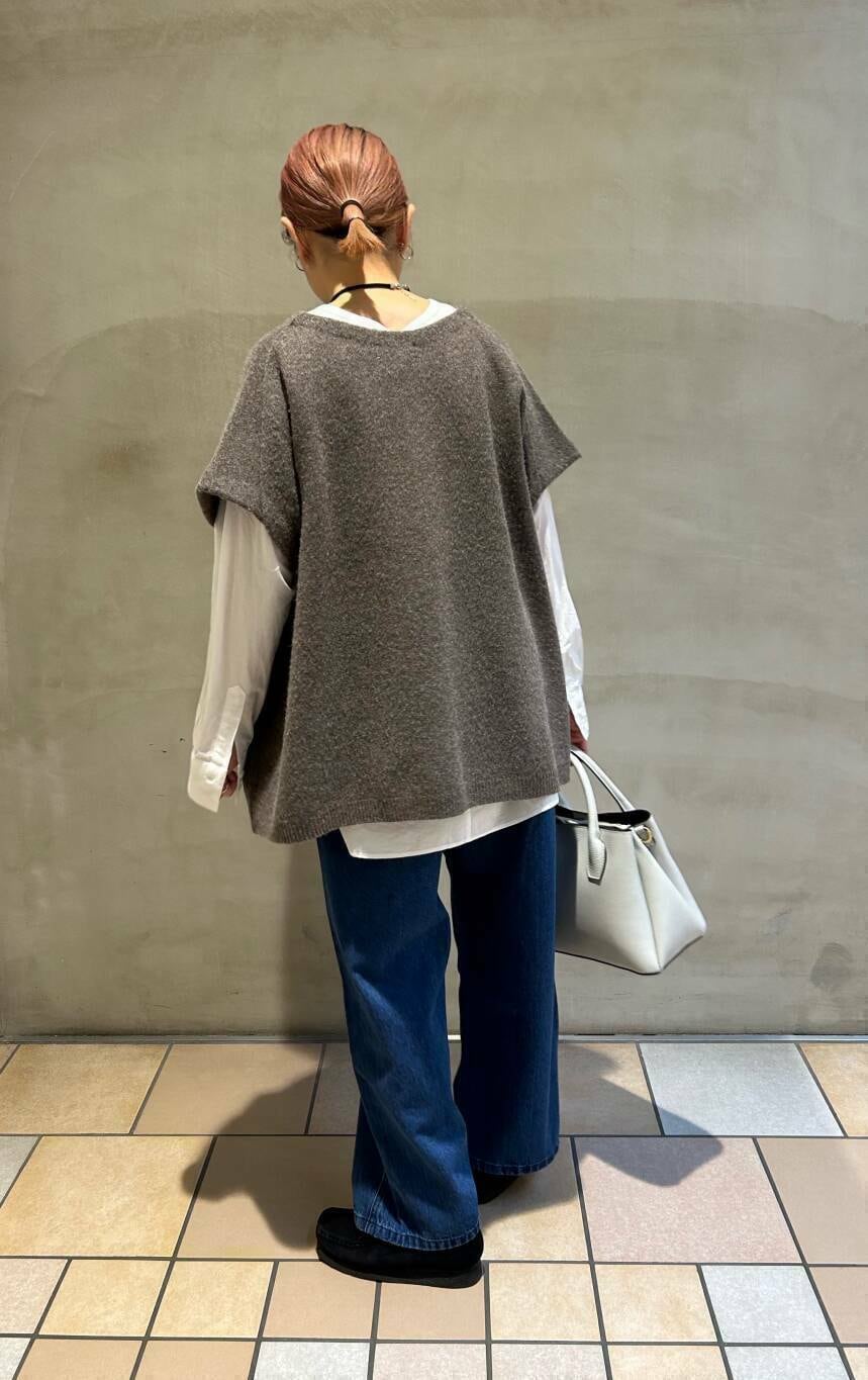 ブラック系のブーツ、ホワイト系のショルダーバッグ、ブルー系のデニムパンツを着用したレディースの冬コーディネートの2枚目の写真