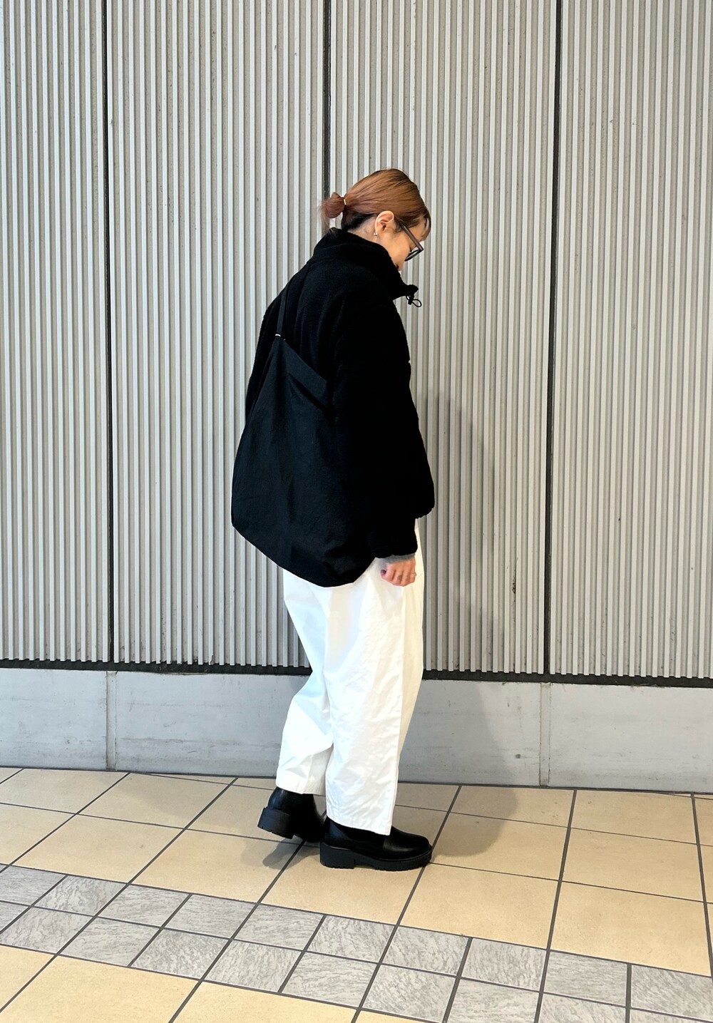 ブラック系のブルゾン、ホワイト系のその他パンツ、ブラック系のブーツを着用したレディースの冬コーディネートの2枚目の写真