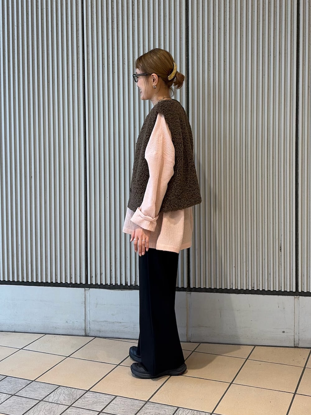 ピンク系のシャツ/ブラウス、ブラウン系のダウンベスト、ブラック系のその他パンツを着用したレディースの秋コーディネートの2枚目の写真