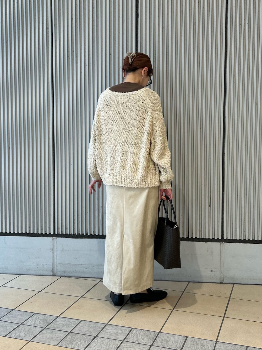 ベージュ系のスカート、ブラック系のローファー、ブラウン系のショルダーバッグを着用したレディースの春コーディネートの2枚目の写真