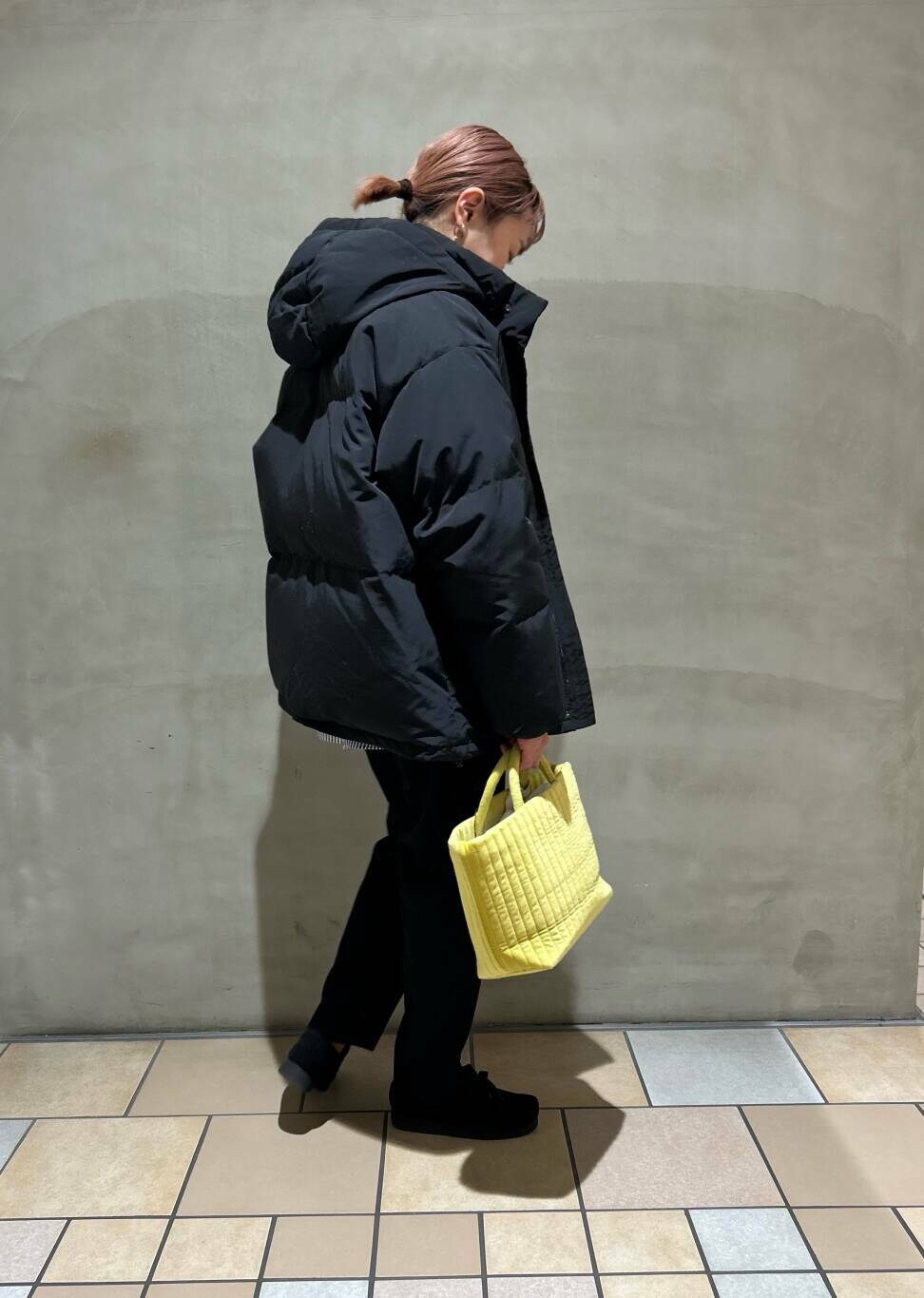 ブルー系のシャツ/ブラウス、イエロー系のトートバッグ、ブラック系のダウンジャケット/コートを着用したレディースの冬コーディネートの3枚目の写真