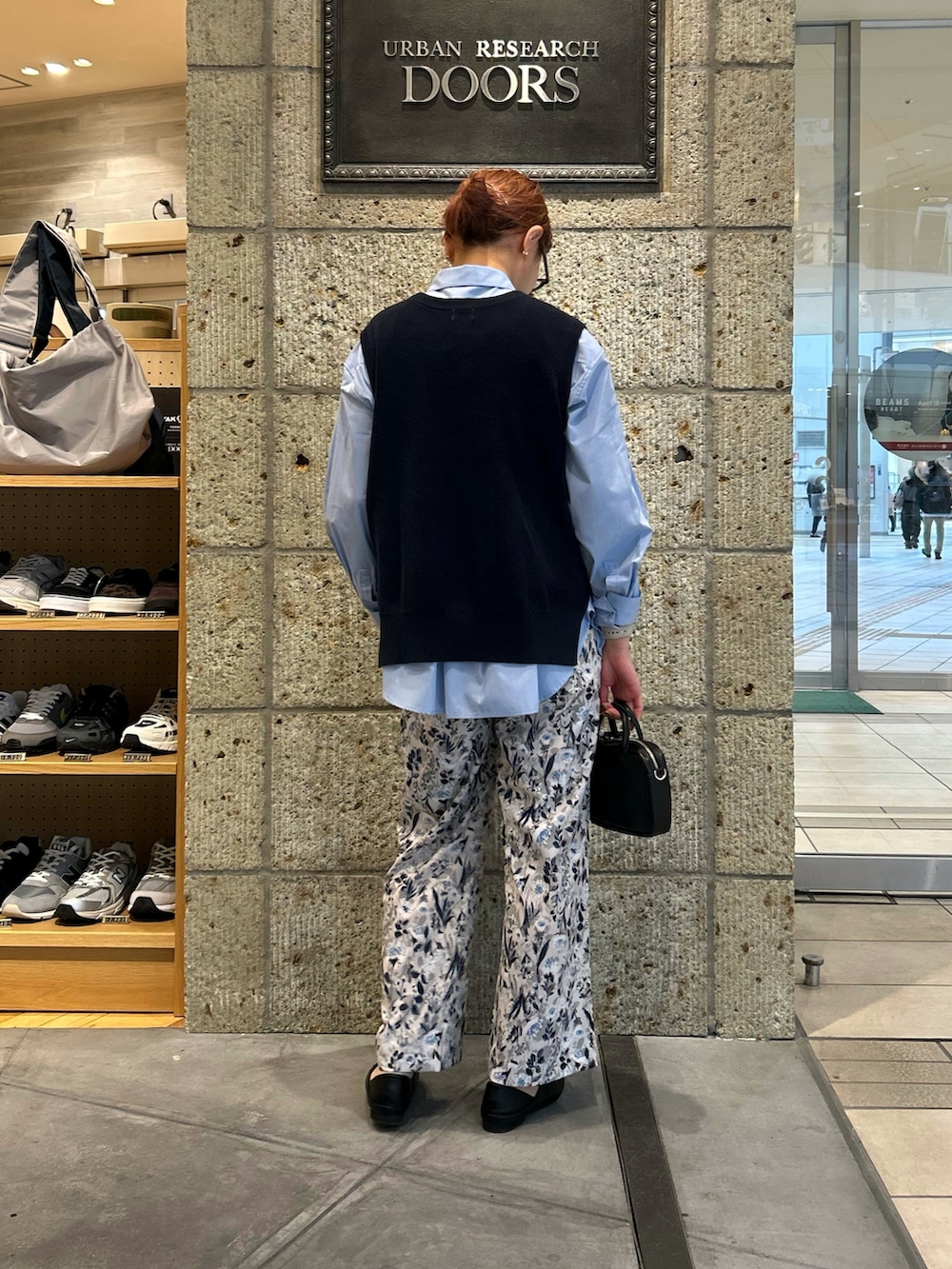 ブルー系のシャツ/ブラウス、グレー系のその他パンツ、ブラック系のその他シューズを着用したレディースの春コーディネートの2枚目の写真