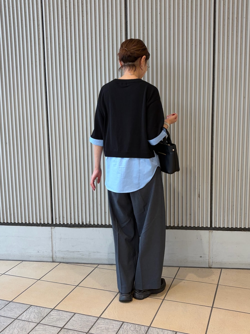 ブラック系のニット/セーター、グレー系のその他パンツ、ブラック系のスニーカーを着用したレディースの夏コーディネートの2枚目の写真
