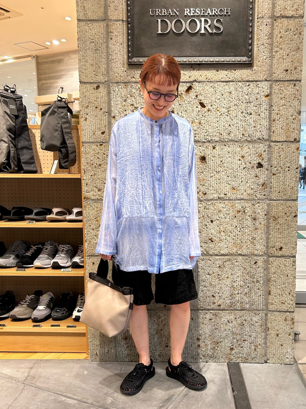 ブルー系のシャツ/ブラウス、ブラック系のその他パンツ、グレー系のハンドバッグを着用したレディースの春コーディネートの3枚目の写真