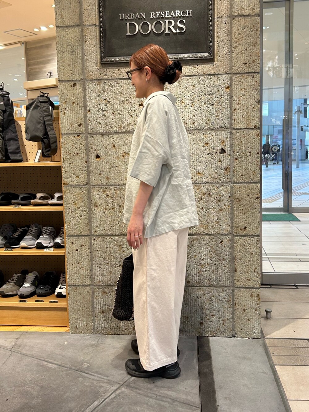 グリーン系のシャツ/ブラウス、ホワイト系のその他パンツ、ブラック系のトートバッグを着用したレディースの春コーディネートの2枚目の写真