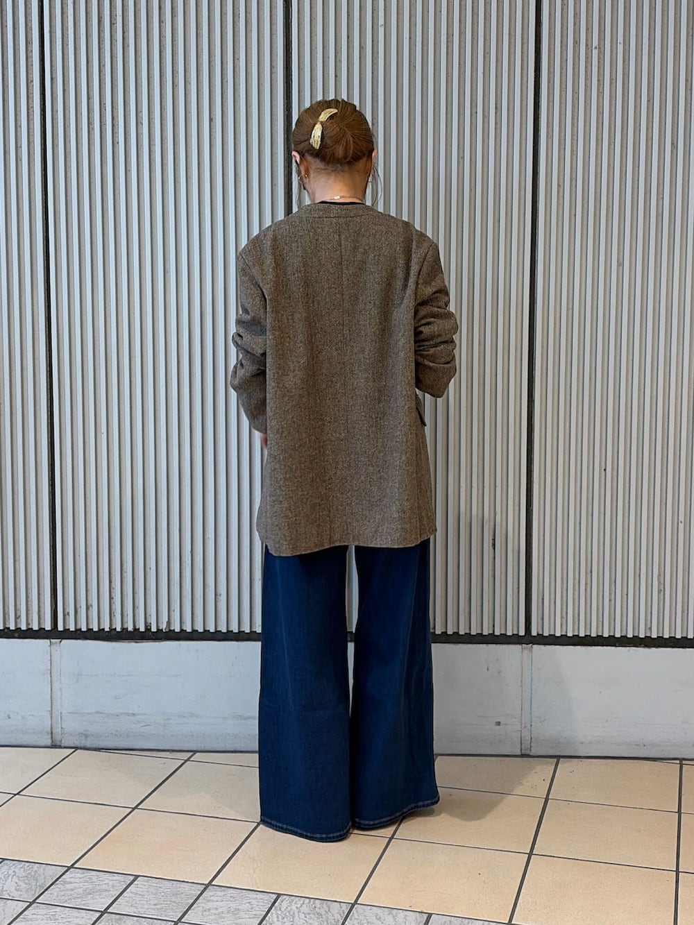 ブルー系のデニムパンツ、ブラウン系のノーカラージャケット、ブラック系のシャツ/ブラウスを着用したレディースの秋コーディネートの3枚目の写真