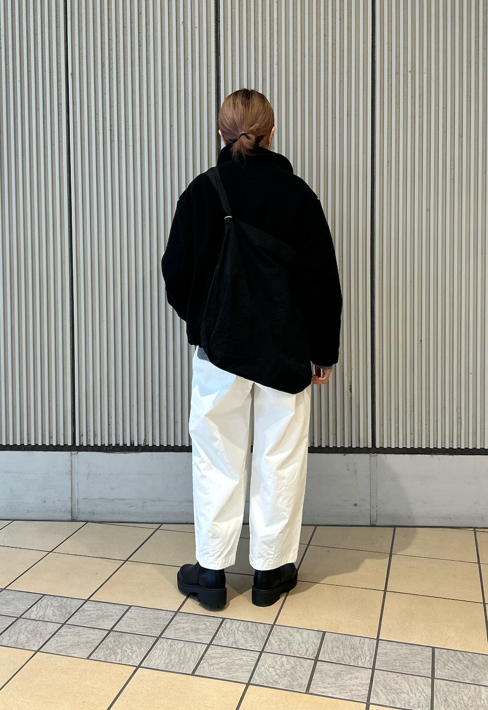 ブラック系のブルゾン、ホワイト系のその他パンツ、ブラック系のブーツを着用したレディースの冬コーディネートの3枚目の写真