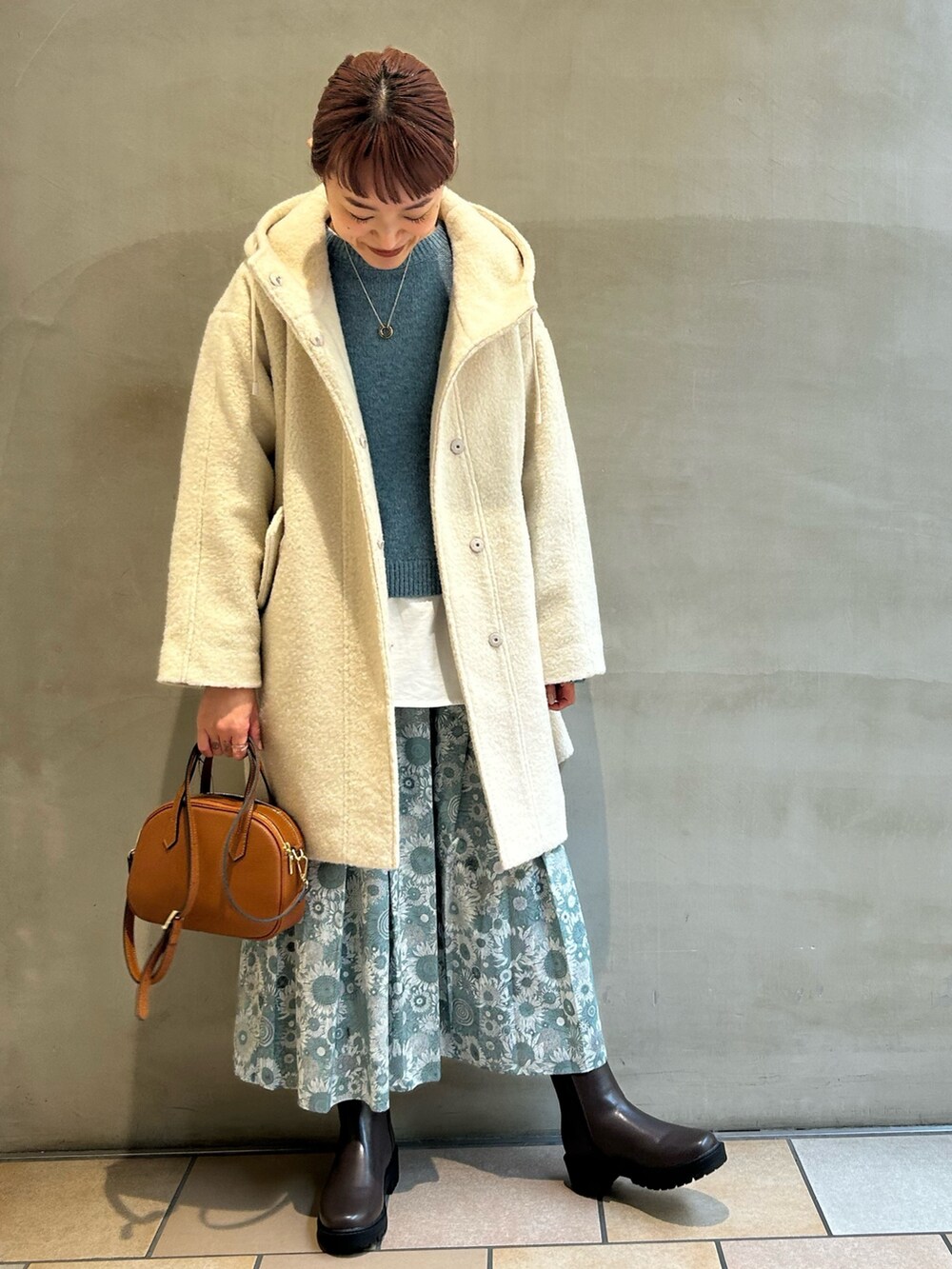 ホワイト系のTシャツ/カットソー、ブルー系のニット/セーター、ブラック系のスカートを着用したレディースの冬コーディネートの4枚目の写真