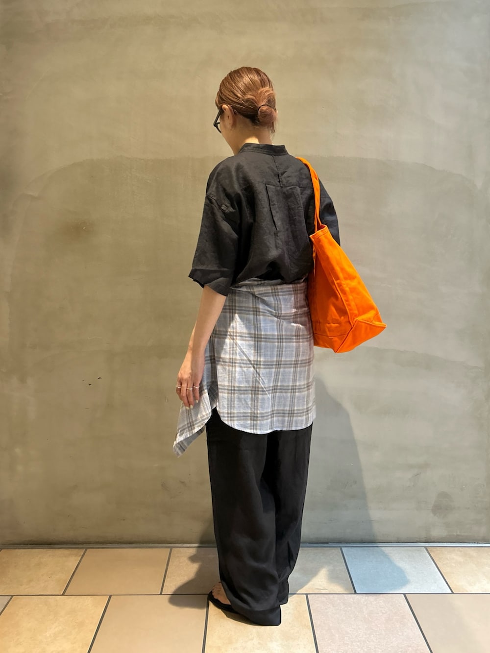 グレー系のその他パンツ、ブラック系のサンダル、オレンジ系のトートバッグを着用したレディースの春コーディネートの2枚目の写真