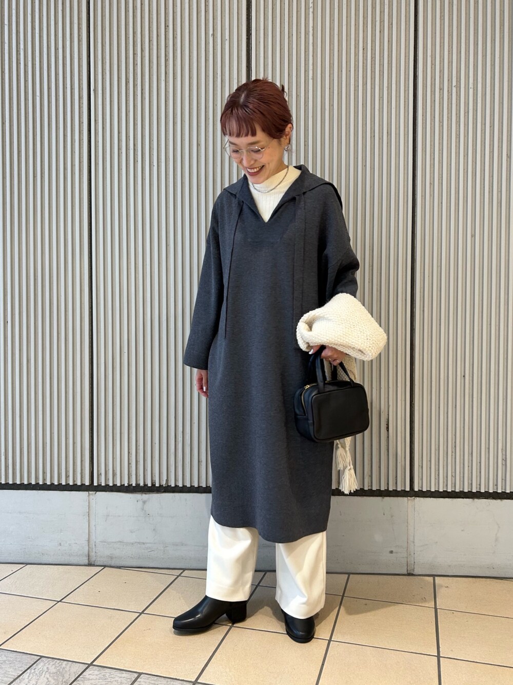 グレー系のワンピース、ホワイト系のその他パンツ、ブラック系のボストンバッグを着用したレディースの秋コーディネートの4枚目の写真