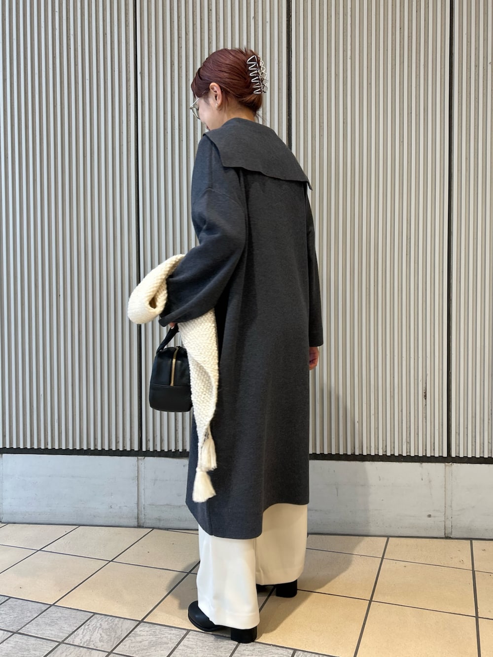 グレー系のワンピース、ホワイト系のその他パンツ、ブラック系のボストンバッグを着用したレディースの秋コーディネートの5枚目の写真