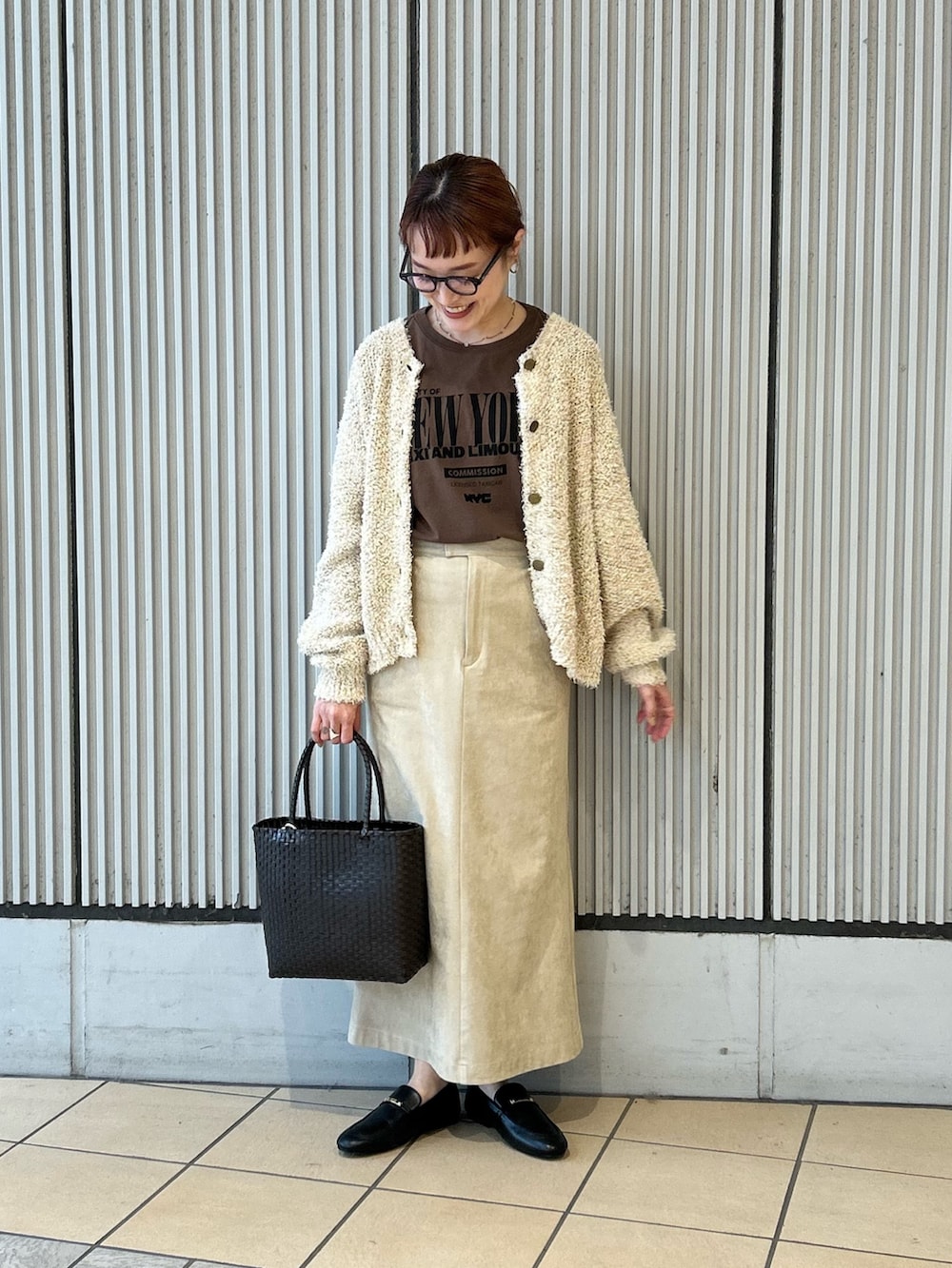 ベージュ系のスカート、ブラック系のローファー、ブラウン系のショルダーバッグを着用したレディースの春コーディネートの3枚目の写真