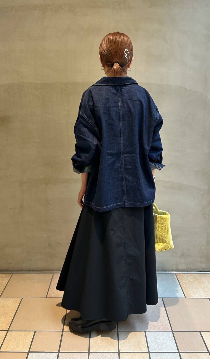 イエロー系のトートバッグ、ホワイト系のTシャツ/カットソー、ブラック系のブーツを着用したレディースの秋コーディネートの5枚目の写真