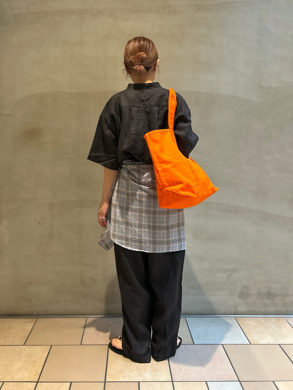 グレー系のその他パンツ、ブラック系のサンダル、オレンジ系のトートバッグを着用したレディースの春コーディネートの3枚目の写真