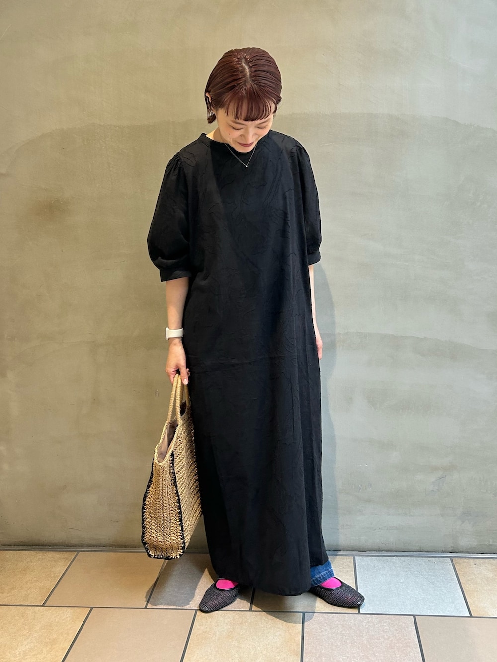 ブラック系のワンピース、ブルー系のデニムパンツ、ブラック系のパンプスを着用したレディースの夏コーディネートの2枚目の写真